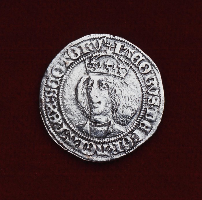 Silver coin with James III's head engraved and text around the outside