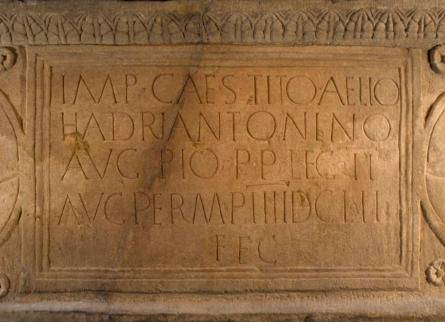 Closeup of the central inscription on the Bridgeness slab, with four lines of abbreviated Latin text.