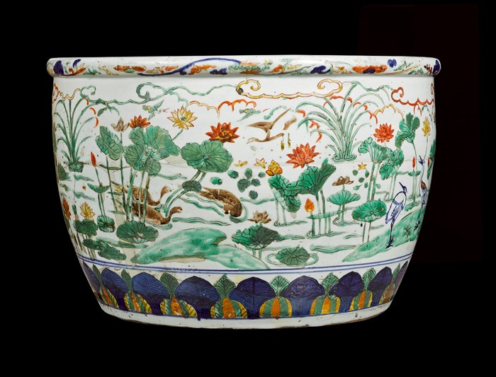 A large ceramic bowl, almost as tall as it is wide, slightly tapered at the bottom. The bowl is decorated with a colourful painted scene of large flowers made to look like trees, water ripples, and birds.