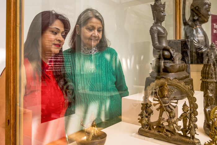 NKS members look through a cabinet at the sculpture of Durga.