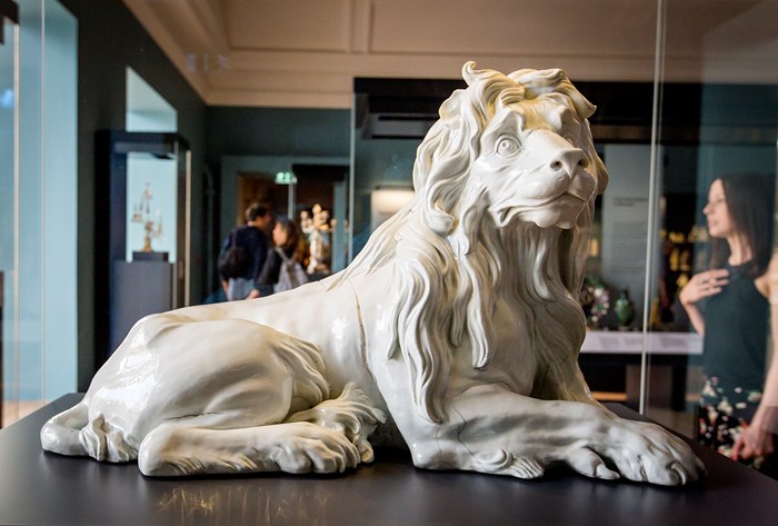 Sculpture of the Meissen lion in a glass cabinet.