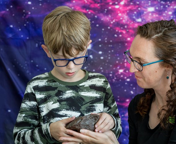 A child and adult looking at a geological specimen.