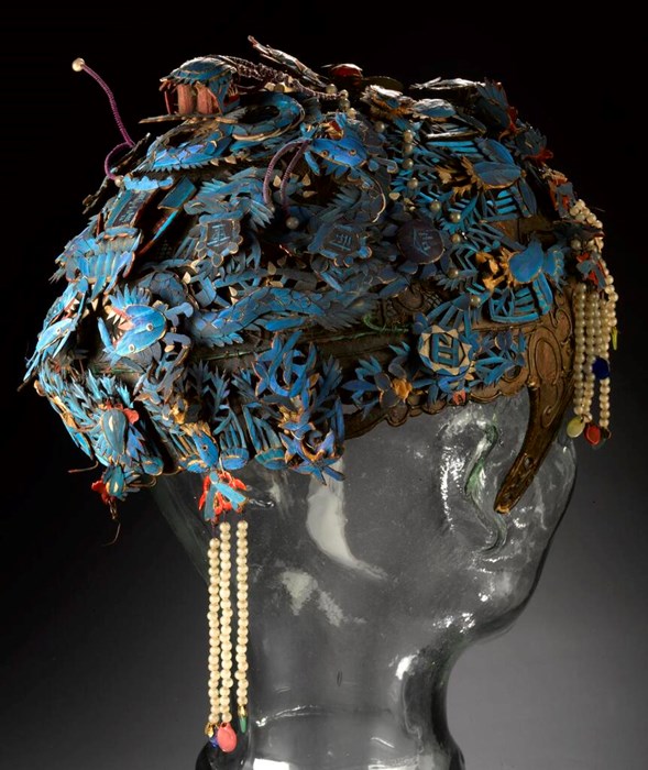 An intricately decorated blue headdress with cream beaded tassels