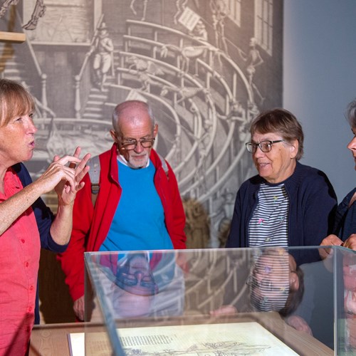 A group of visitors on a BSL tour of an exhibition space